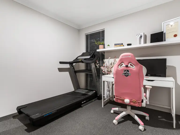 Bureau à domicile avec un tapis de course posé à côté du poste de travail